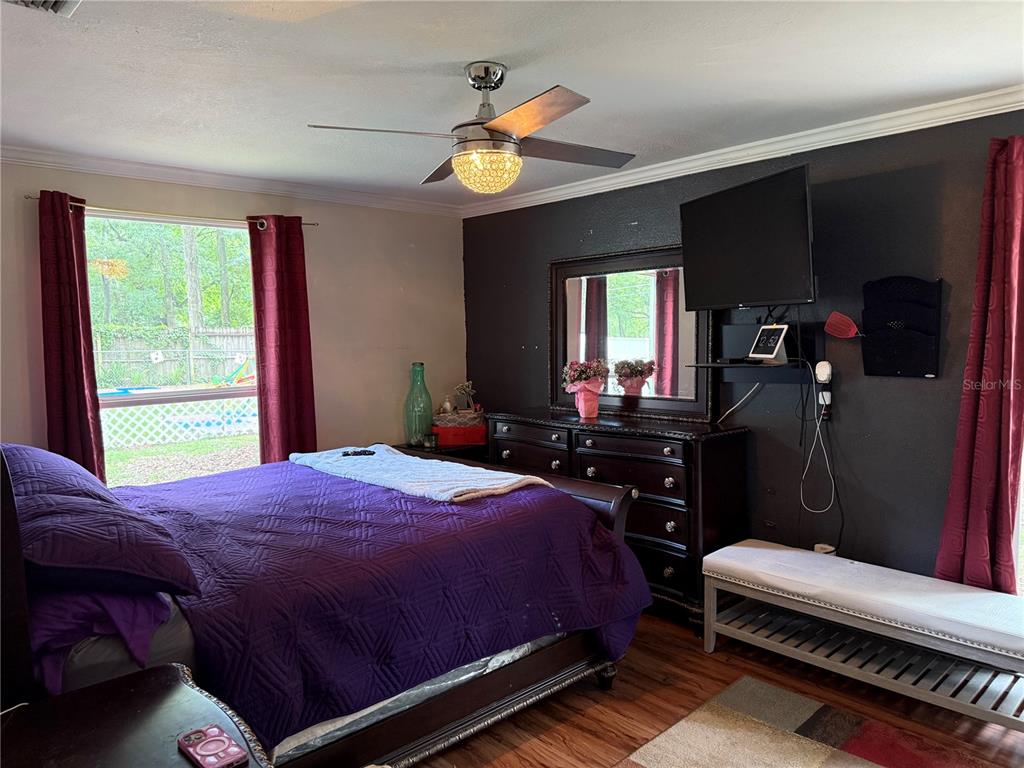 7713 Southwest 8th Avenue Gainesville, FL 32607 - Photo 13 of 32 a bedroom with a bed and wooden floor
