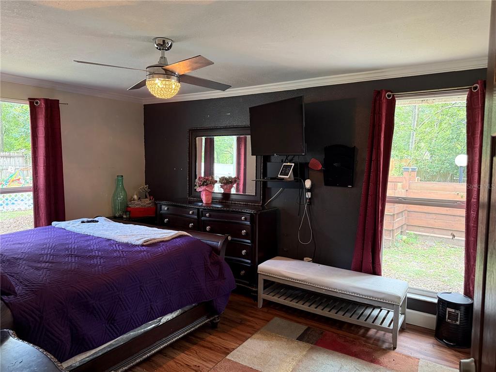 7713 Southwest 8th Avenue Gainesville, FL 32607 - Photo 14 of 32 a bedroom with a bed and large windows