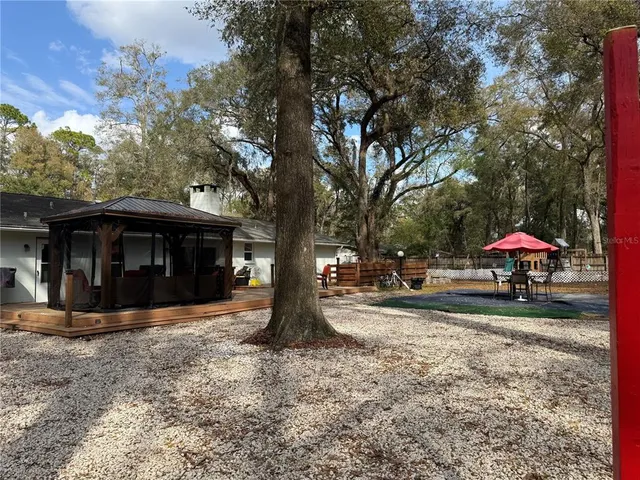 a view of a house with a yard and a large tree