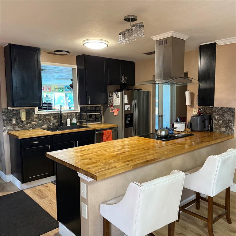 7713 Southwest 8th Avenue Gainesville, FL 32607 - Photo 6 of 32 a kitchen with stainless steel appliances kitchen island granite countertop a table chairs in it and wooden floors