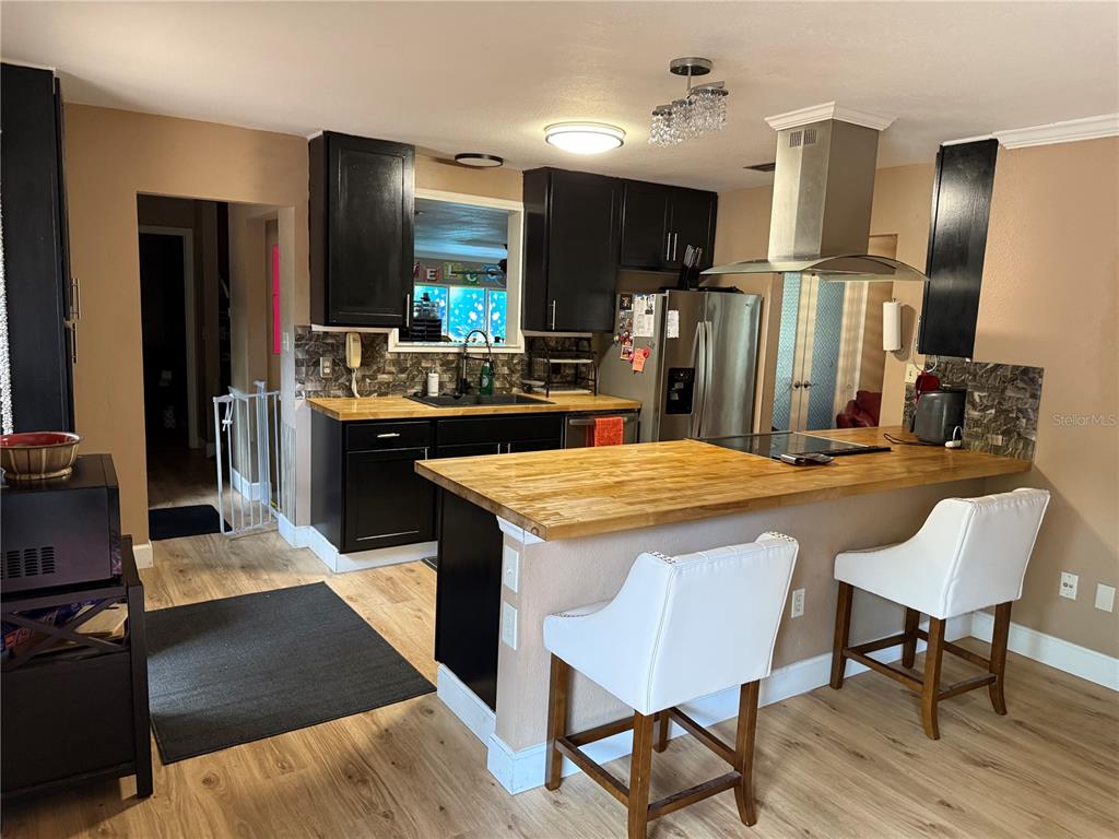7713 Southwest 8th Avenue Gainesville, FL 32607 - Photo 7 of 32 a kitchen with stainless steel appliances kitchen island granite countertop a refrigerator a stove top oven and sink