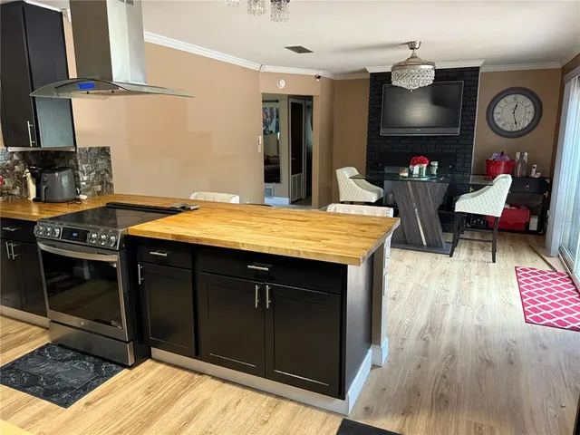 a open kitchen with stainless steel appliances granite countertop a stove and a wooden cabinets