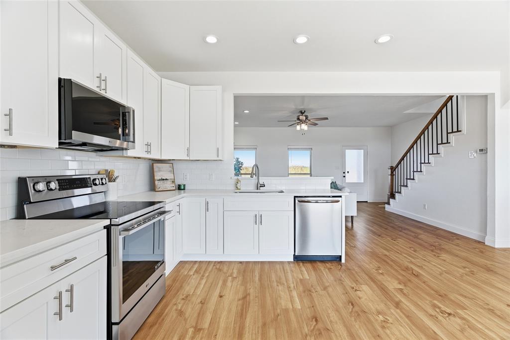 846 Old Tioga Road Gunter, TX 75058 - Photo 6 of 38 a kitchen with a sink a microwave and cabinets