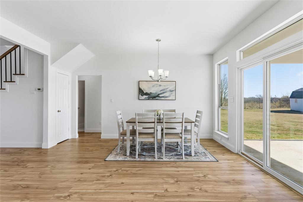 846 Old Tioga Road Gunter, TX 75058 - Photo 9 of 38 a dining room with wooden floor a chandelier a glass table and chairs
