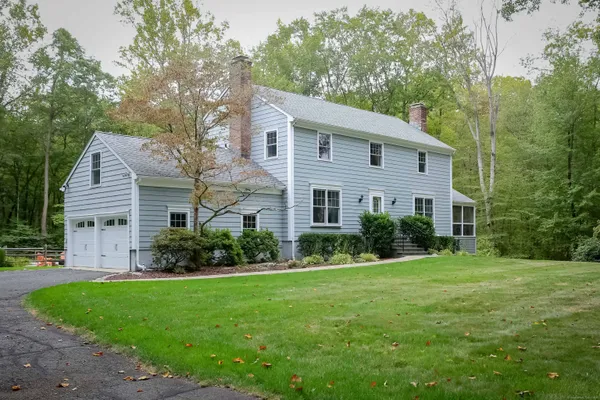 a aerial view of a house next to a big yard and large trees
