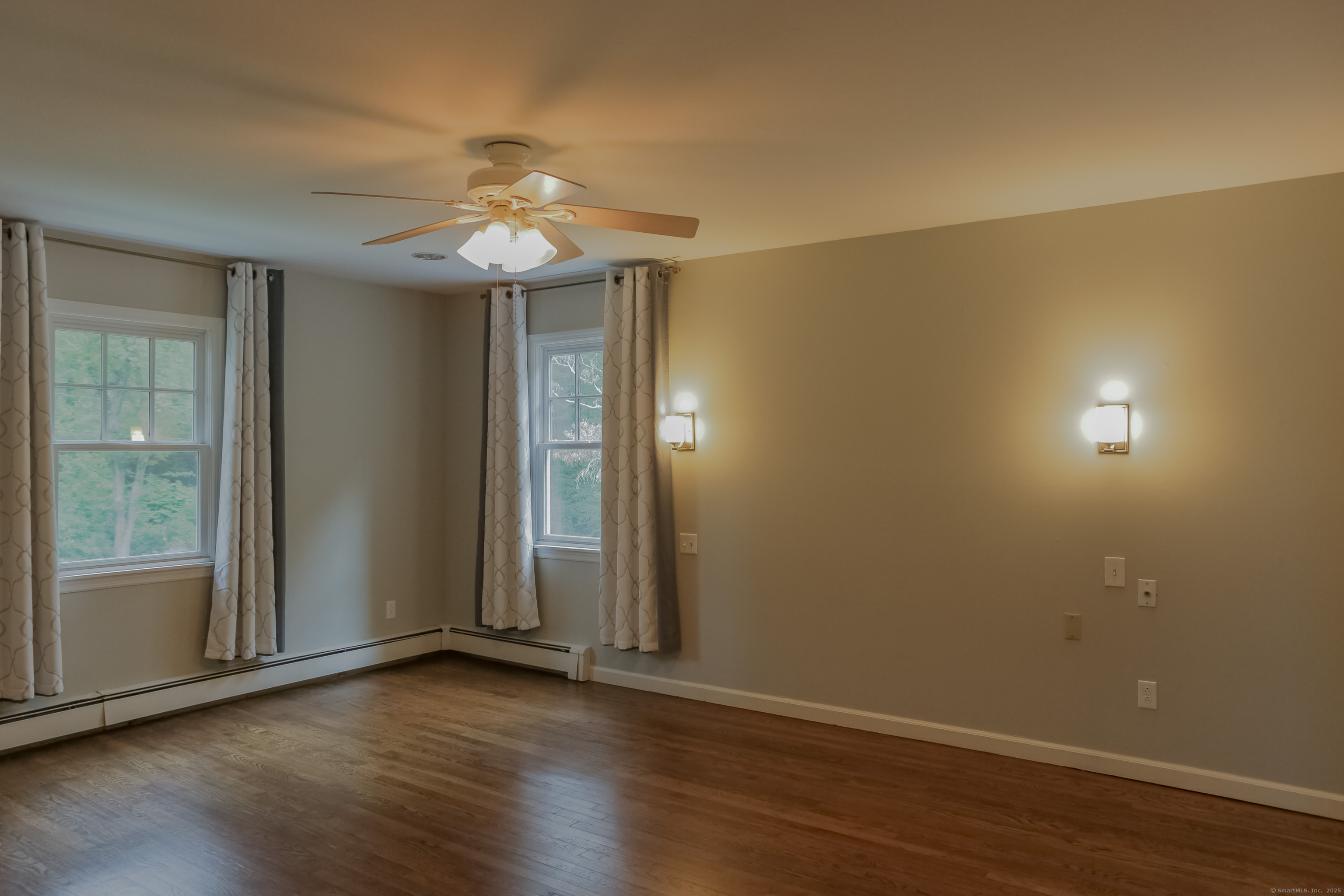 161 Foggwood Road Fairfield, CT 06824 - Photo 13 of 34 an empty room with wooden floor chandelier fan and windows