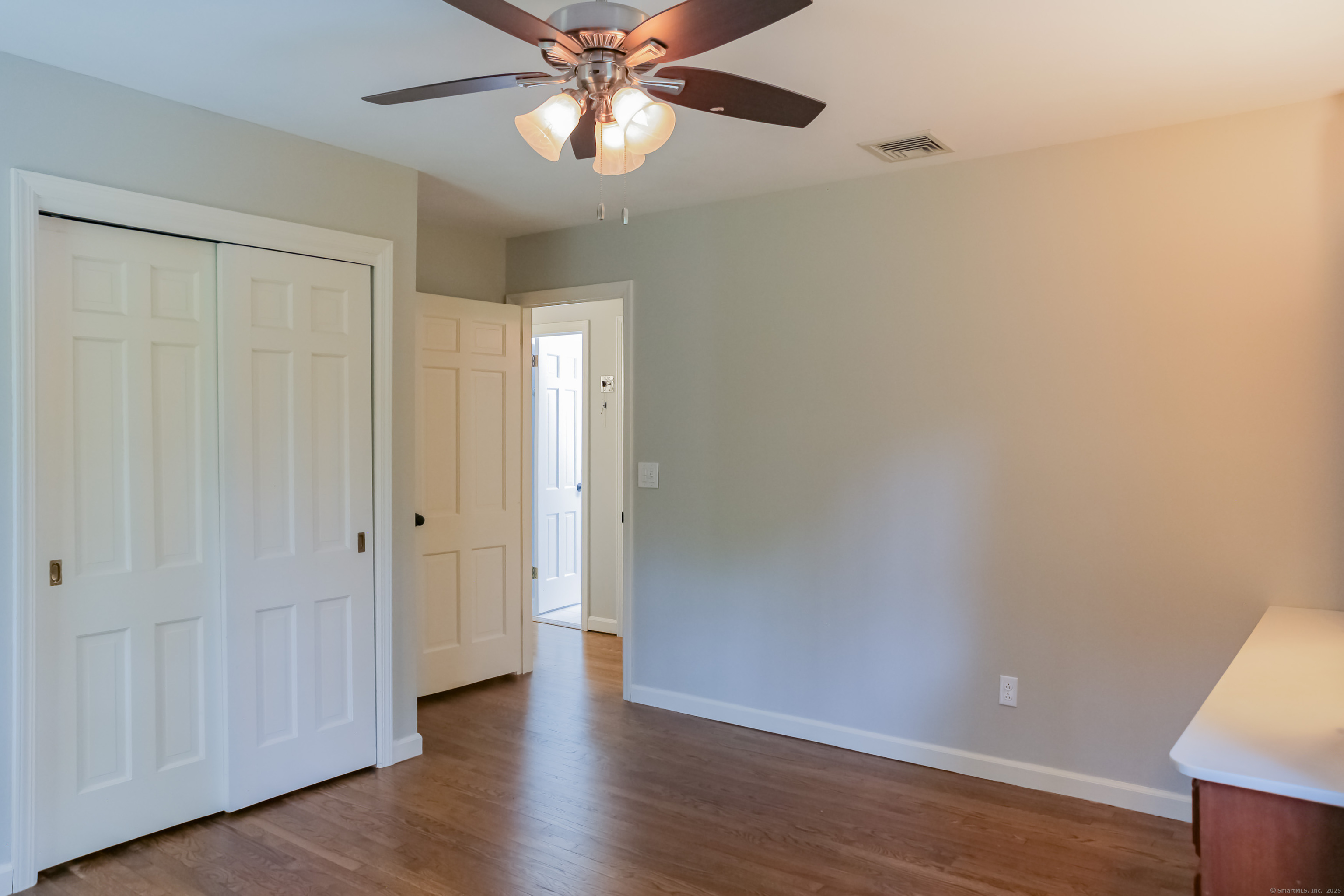 161 Foggwood Road Fairfield, CT 06824 - Photo 21 of 34 an empty room with wooden floor closet fan and windows