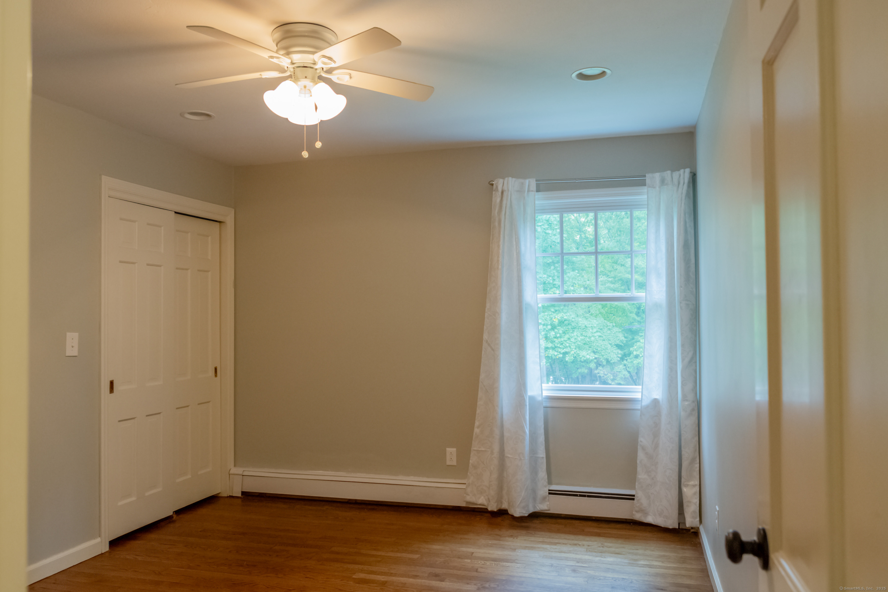 161 Foggwood Road Fairfield, CT 06824 - Photo 27 of 34 a view of an empty room with a window and wooden floor