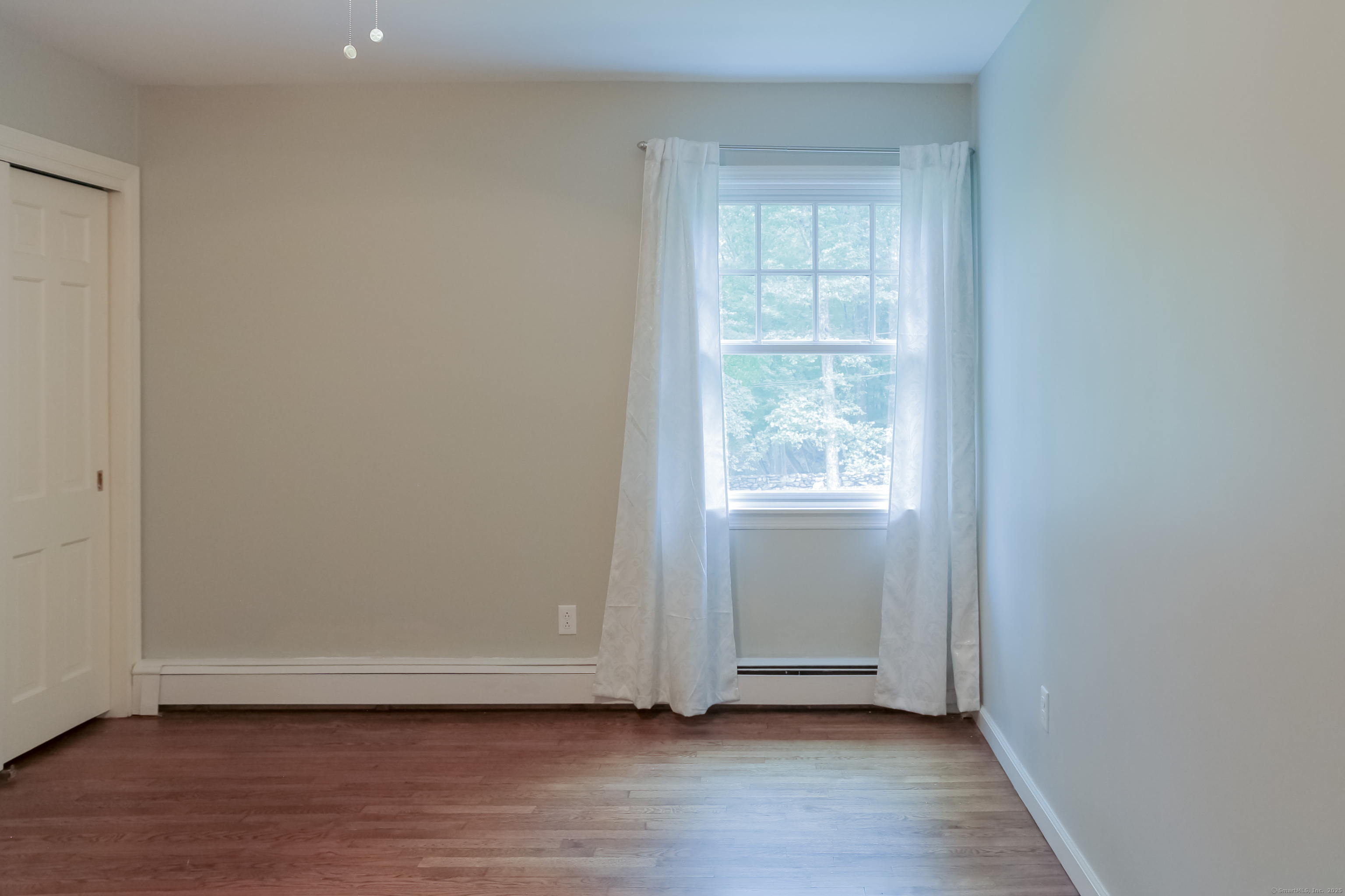 161 Foggwood Road Fairfield, CT 06824 - Photo 28 of 34 an empty room with wooden floor and windows