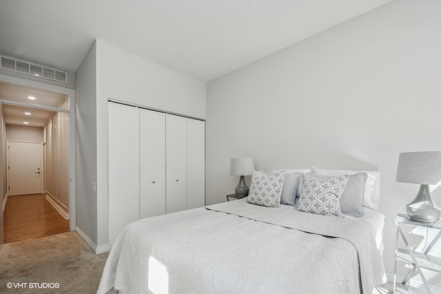 560 West Fulton Street, Unit 504 Chicago, IL 60661 - Photo 14 of 17 a bedroom with a bed and a night stand