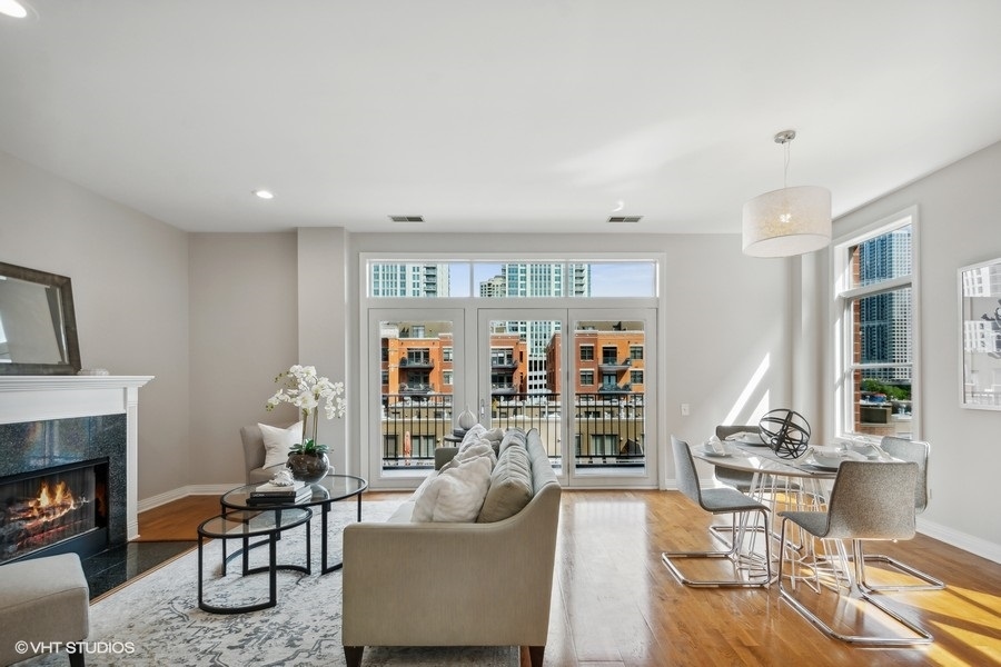 560 West Fulton Street, Unit 504 Chicago, IL 60661 - Photo 4 of 17 a living room with fireplace furniture and a large window
