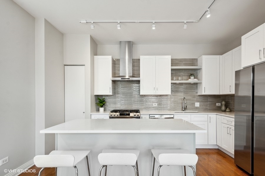 560 West Fulton Street, Unit 504 Chicago, IL 60661 - Photo 6 of 17 a kitchen with a sink a stove a refrigerator and white cabinets