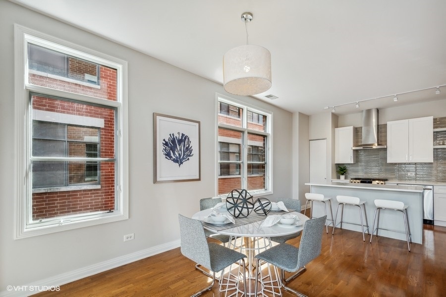 560 West Fulton Street, Unit 504 Chicago, IL 60661 - Photo 8 of 17 a view of a dining room with furniture window and wooden floor