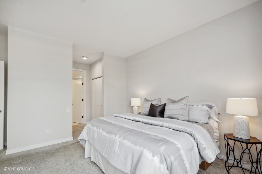 560 West Fulton Street, Unit 504 Chicago, IL 60661 - Photo 10 of 17 a bedroom with a bed and a lamp on table