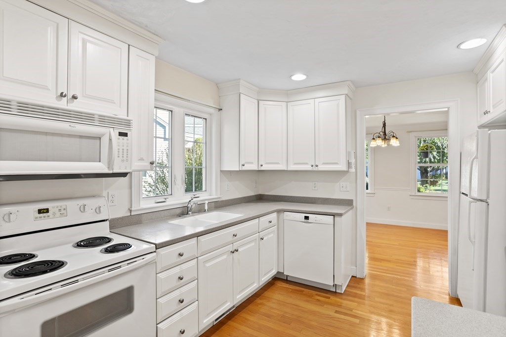 114 Summer Road, Unit 114 Boxborough, MA 01719 - Photo 14 of 42 a kitchen with granite countertop white cabinets and white appliances