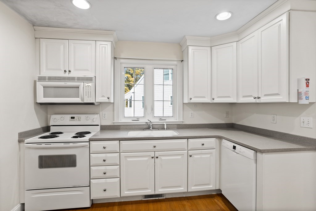 114 Summer Road, Unit 114 Boxborough, MA 01719 - Photo 15 of 42 a kitchen with white cabinets and white appliances