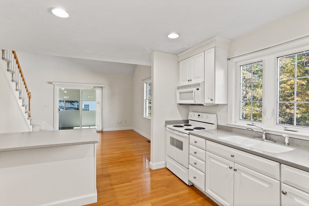 114 Summer Road, Unit 114 Boxborough, MA 01719 - Photo 17 of 42 a kitchen with stainless steel appliances granite countertop a sink stove and cabinets