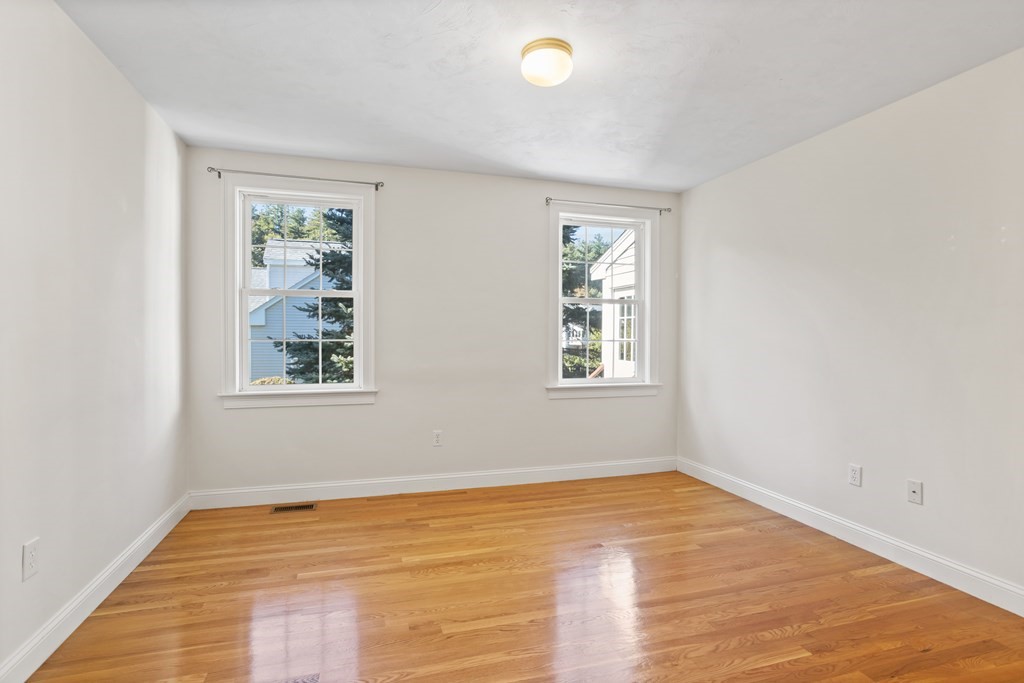 114 Summer Road, Unit 114 Boxborough, MA 01719 - Photo 28 of 42 a view of an empty room with wooden floor and a window