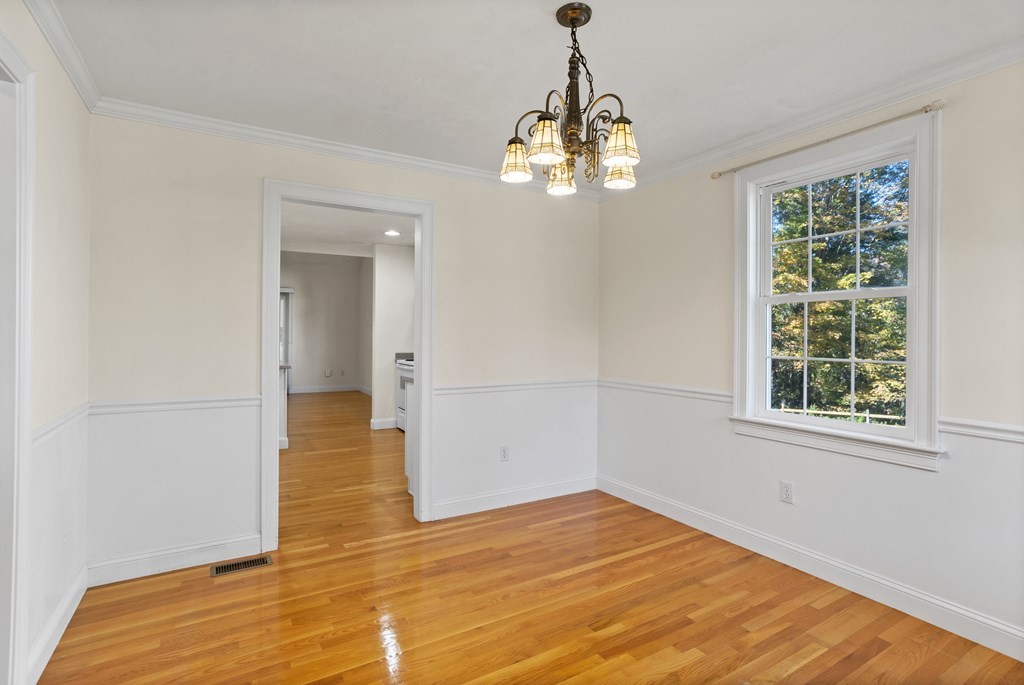 114 Summer Road, Unit 114 Boxborough, MA 01719 - Photo 9 of 42 a view of empty room with wooden floor and chandelier