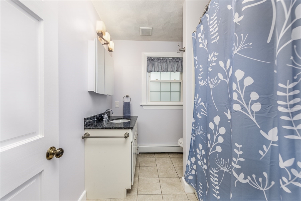 22 Clovelly Street Lynn, MA 01902 - Photo 11 of 28 a kitchen with a stove a sink and a window