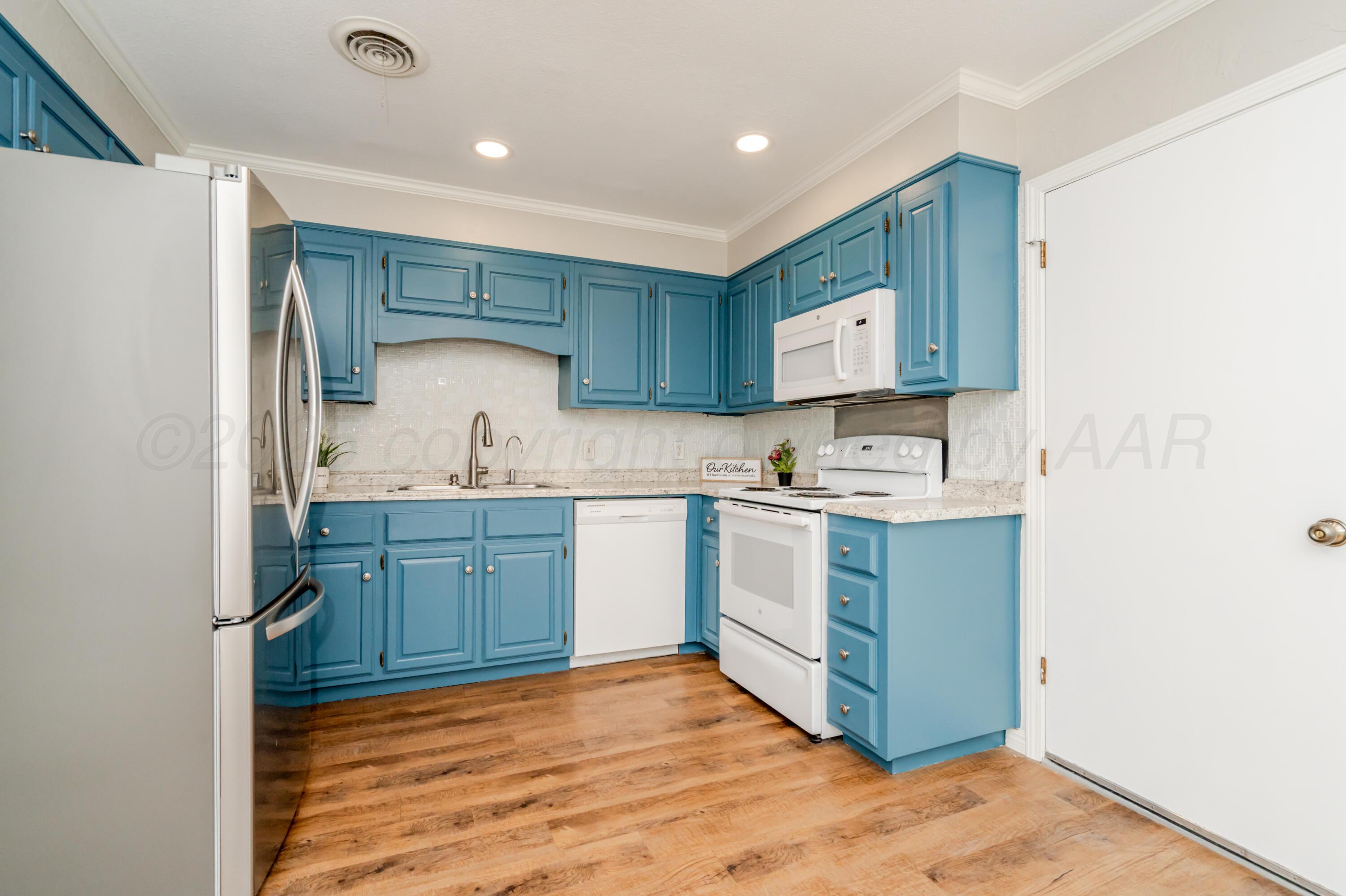 6106 Belpree Road Amarillo, TX 79106 - Photo 17 of 33 a kitchen with a sink cabinets and wooden floor