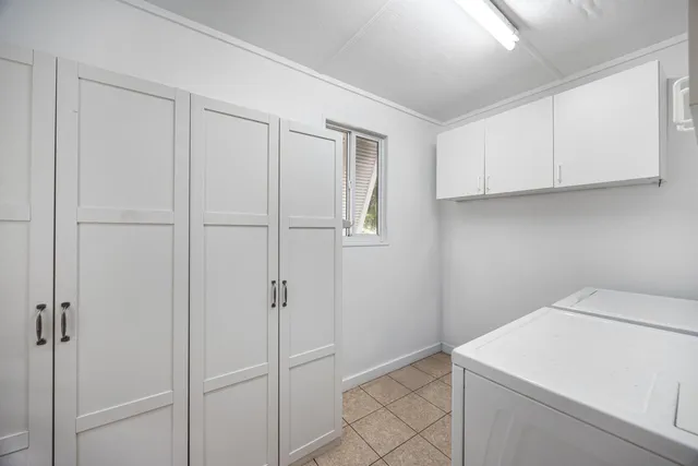 a utility room with cabinets washer and dryer