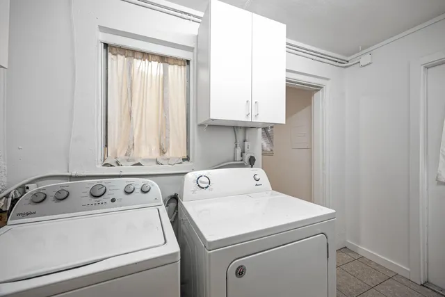 a view of washer and dryer with bathroom in the background