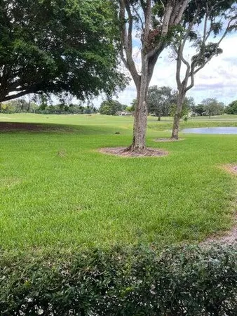 a view of outdoor space with green field and trees