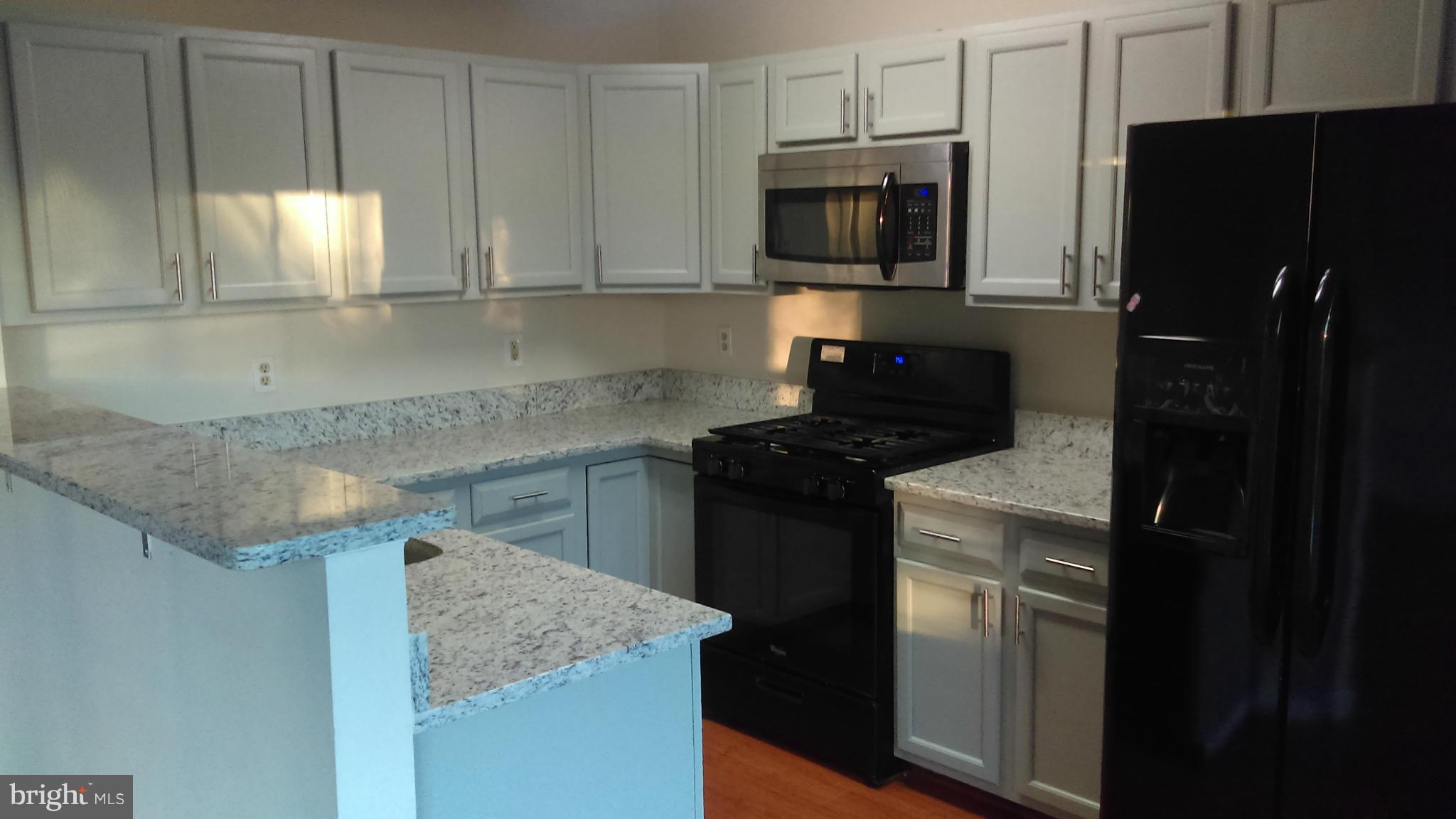 11117 Light Guard Loop Manassas, VA 20109 - Photo 6 of 25 a kitchen with a sink a microwave a refrigerator and cabinets