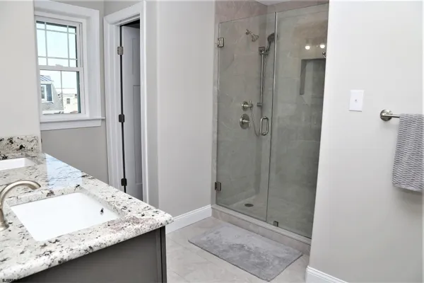 a bathroom with a granite countertop sink and shower