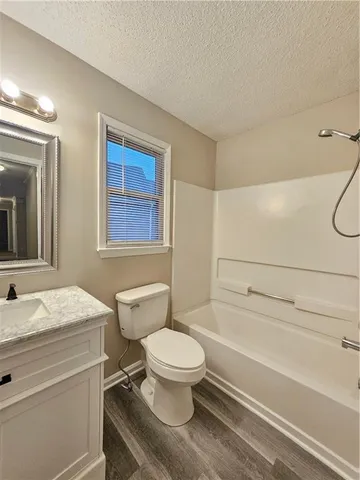 a bathroom with a granite countertop toilet a sink and a bathtub