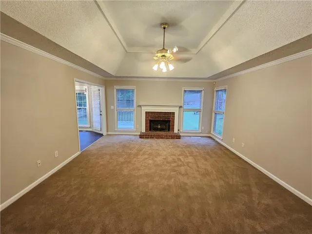 an empty room with a fireplace and chandelier