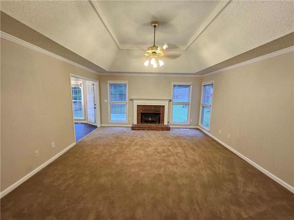 144 Hunters Trace Dallas, GA 30157 - Photo 5 of 34 an empty room with a fireplace and chandelier