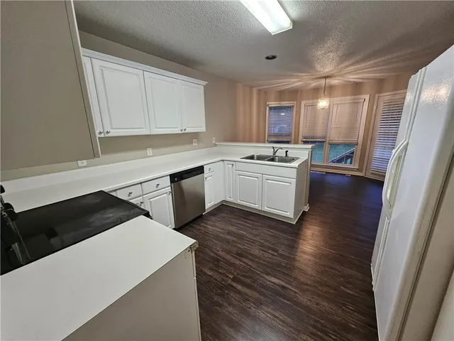 a kitchen with a sink a stove and cabinets