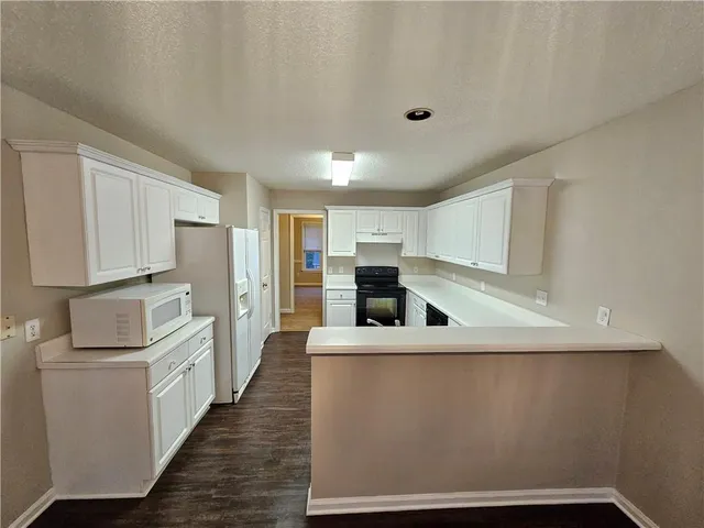 a large white kitchen with stainless steel appliances