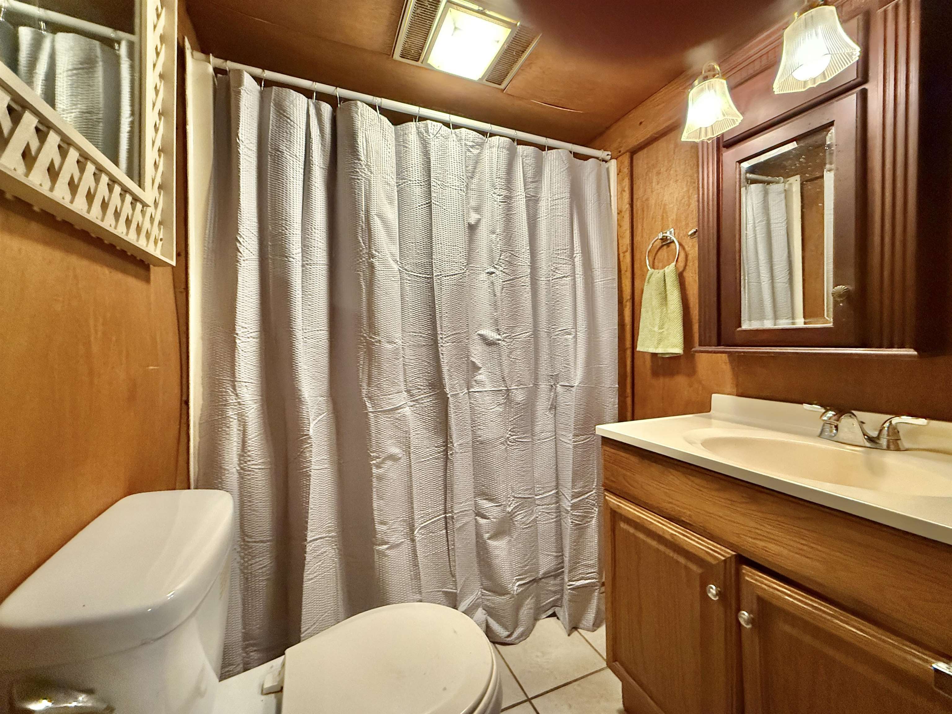 104 Head Of River Road Corbin City, NJ 08270 - Photo 25 of 50 a bathroom with a sink a toilet a mirror and shower curtain