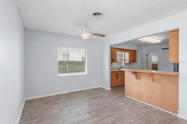 a view of open kitchen with granite countertop cabinets and window