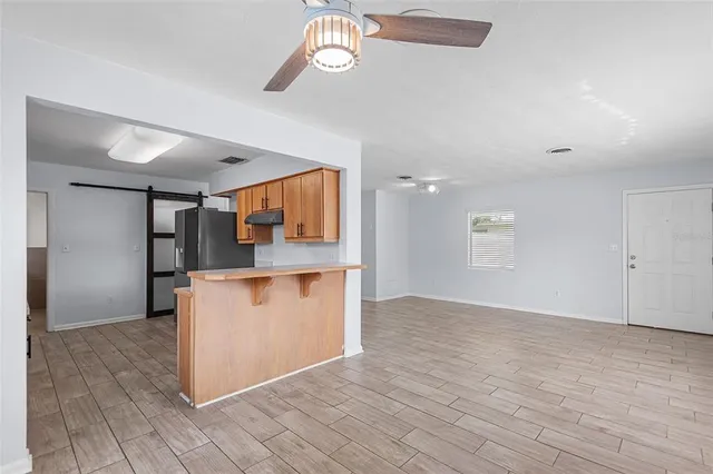 a large kitchen with stainless steel appliances granite countertop a sink and a refrigerator