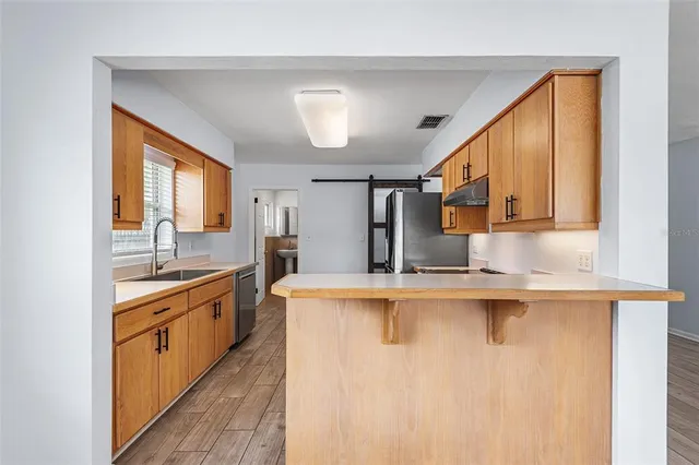 a kitchen with wooden cabinets and stainless steel appliances