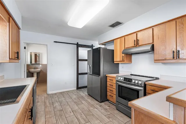 a kitchen with stainless steel appliances granite countertop a refrigerator and a stove