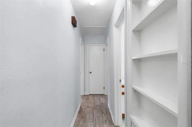 an empty room with wooden floor ceiling fan and windows