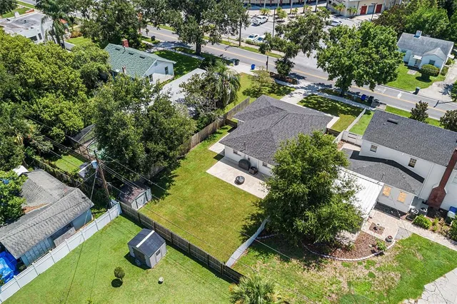 an aerial view of residential houses with outdoor space and trees