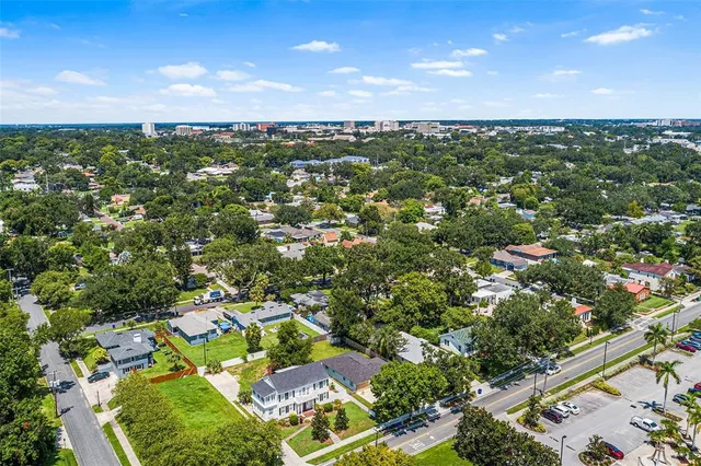 an aerial view of residential houses with outdoor space and trees