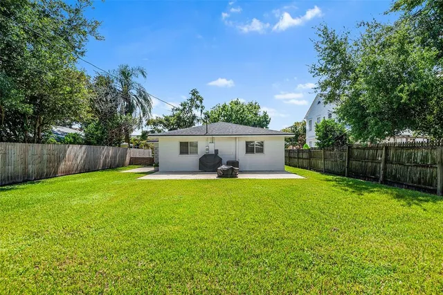 a view of a house with backyard and a tree