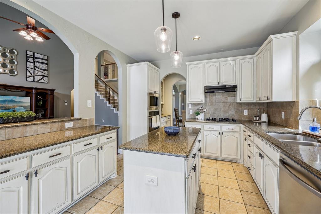 5603 Blazing Star Road Frisco, TX 75036 - Photo 12 of 39 a kitchen with kitchen island granite countertop a sink cabinets and stainless steel appliances