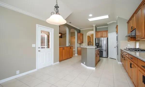 a kitchen with granite countertop a refrigerator and a stove top oven