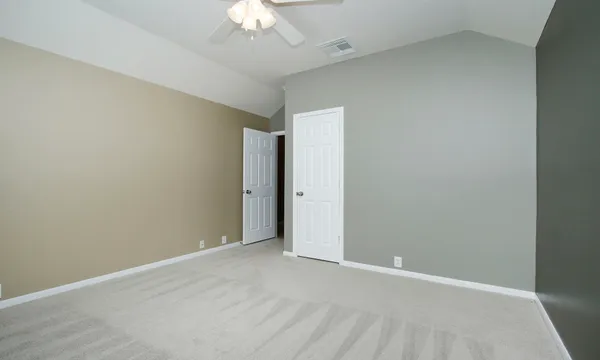 a view of an empty room with a chandelier fan