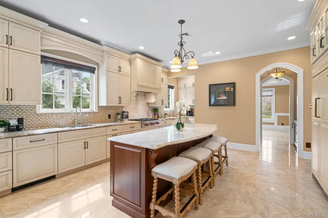 a large kitchen with kitchen island a sink a stove a dining table and chairs