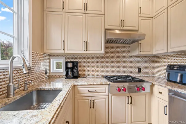 a kitchen with stainless steel appliances granite countertop a sink stove and cabinets