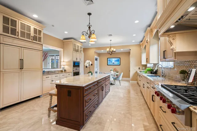a large kitchen with stainless steel appliances a sink and cabinets